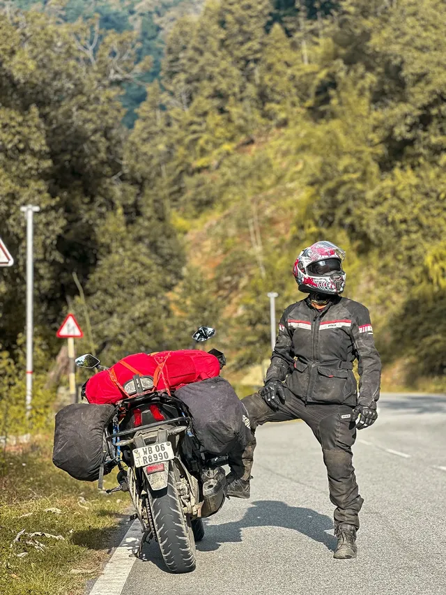Instagram post by @adventurousbangali for Bajaj Auto. Caption reads: Like these roads, life isn't straight, but every....