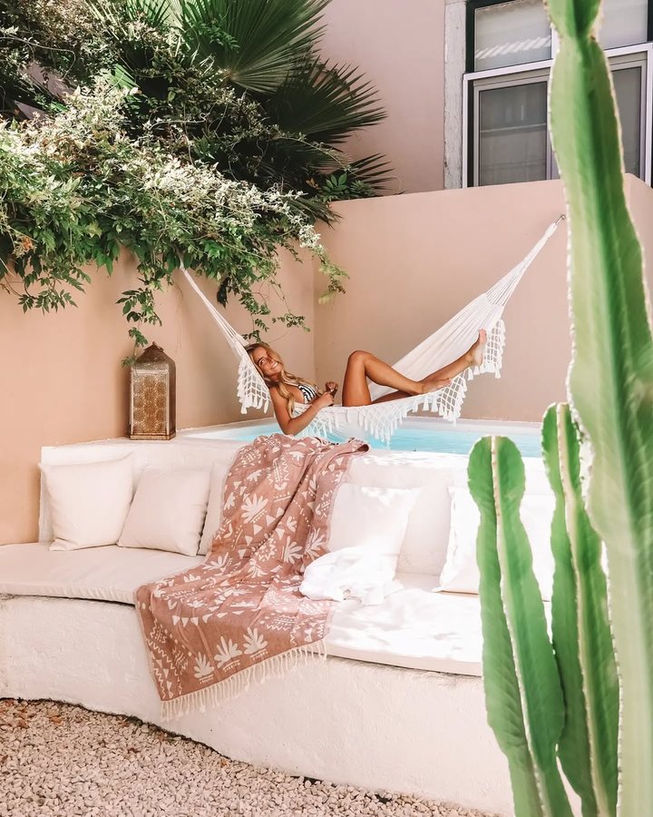 Instagram post by @leonormacedo for Sand Cloud. Caption reads: 🐥🌻 If the sun is out, I'm smiling.