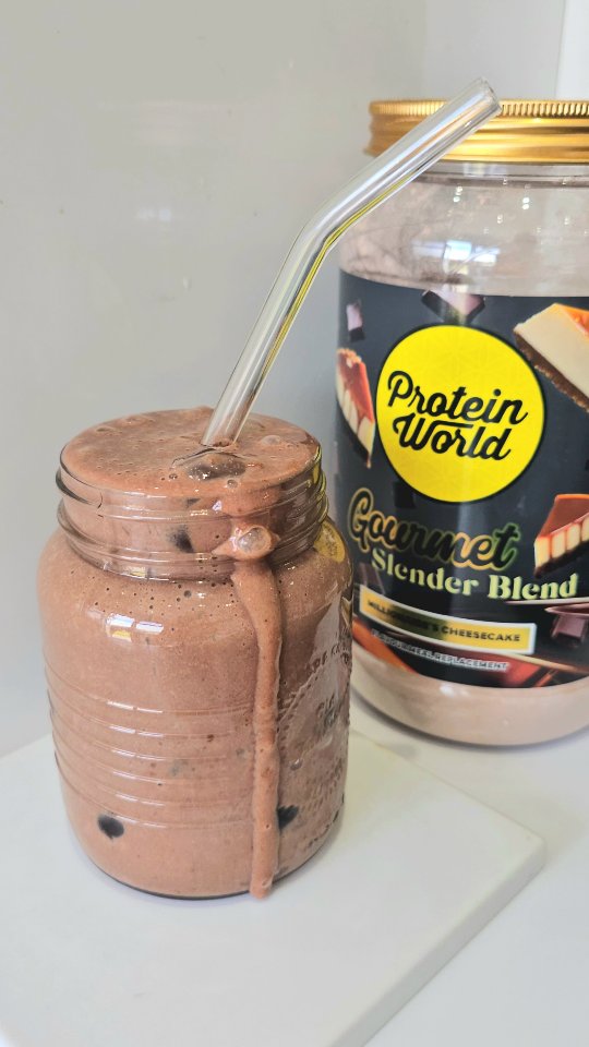 Instagram post by @social_mums_ for Protein World. Caption reads: [...] 🤤 Millionaire Cheesecake Smoothie....