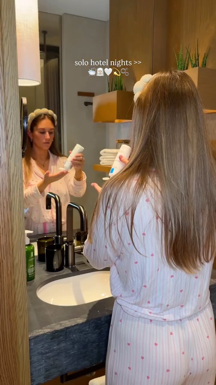 Instagram post by @byemmaleah for OUAI. Caption reads: solo hotel nights >> 🛁🧖🏼‍♀️🤍💫🫧

always the....