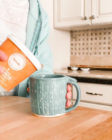 Instagram post by @sweetcreekmoon for Brodo. Caption reads: Snow on the ground and warmth in a mug. #ad @brodo....