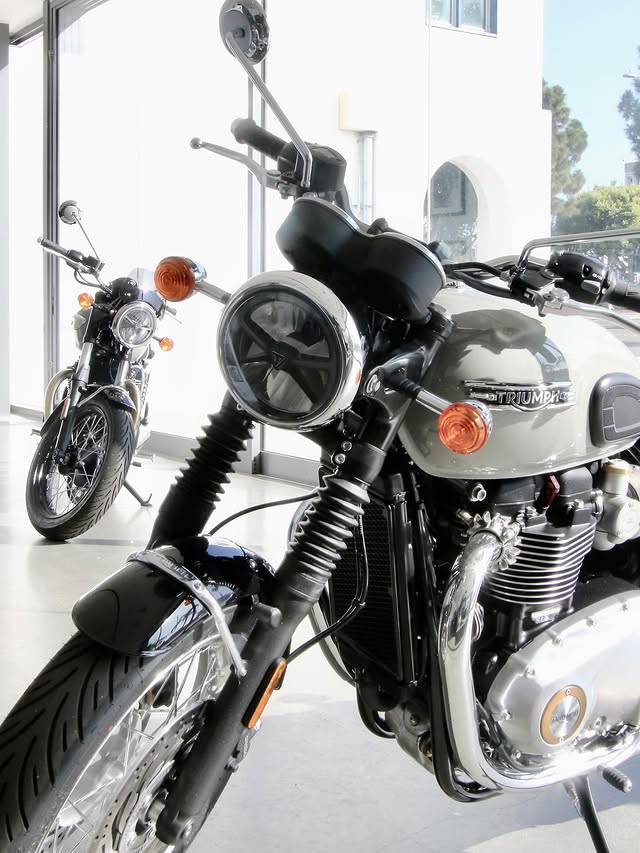 Instagram post by @triumphmotorcyclegirl for Triumph Motorcycles. Caption reads: @triumphamerica + @oceansidemuseum collaborated....