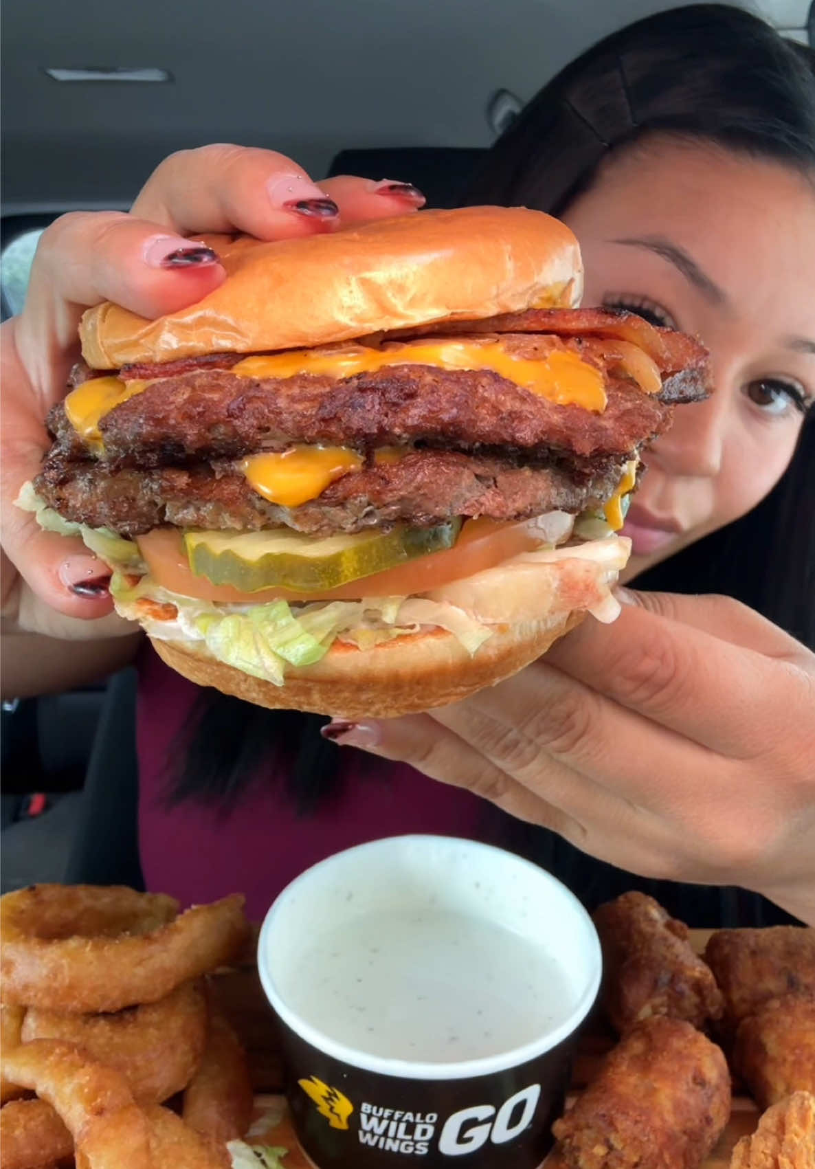 TikTok post by @theangelfoodie for Buffalo Wild Wings. Caption reads: Buffalo Wild Wings ASMR! 🍔💛 You guys, I’m taking....