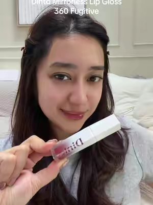 TikTok post by @gellibeansss_ for Dinto Cosmetics. Caption reads: [...] Lip Oil Gloss — 360 Fugitive 🍎 @Dinto....