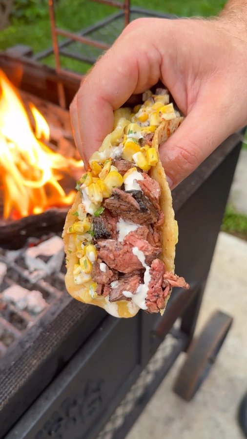 Instagram post by @overthefirecooking for Oklahoma Joe's. Caption reads: Grilled Steak Elote Tacos with @oklahomajoes....
