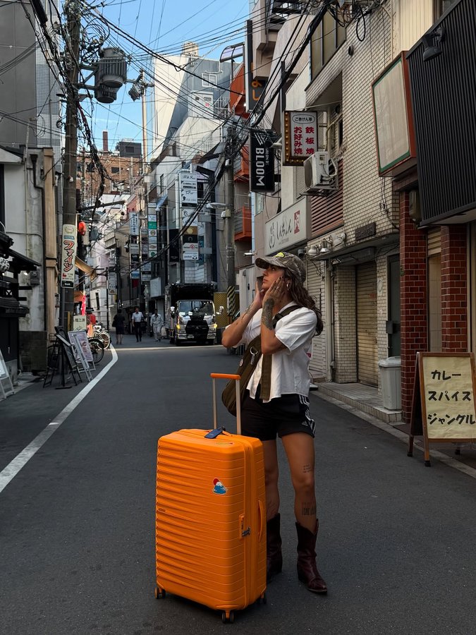 Instagram post by @camamblo for American Tourister. Caption reads: on the go from tokyo to osaka with....
