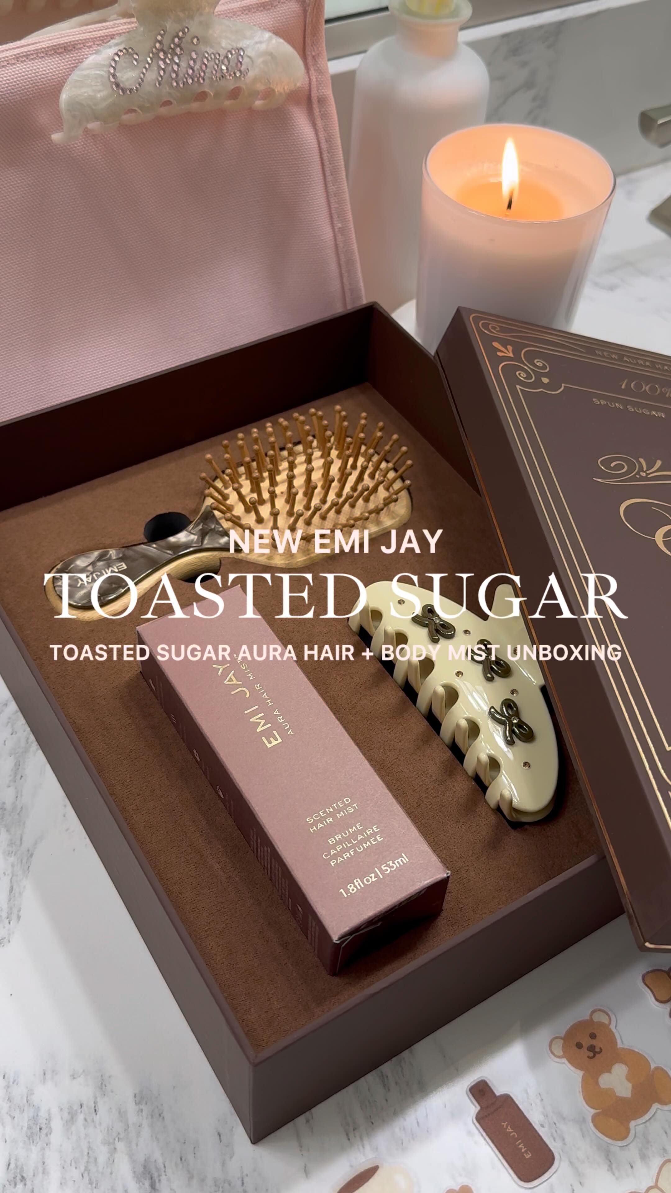 Instagram post by @minaalexis_ for Emi Jay. Caption reads: [...] aura hair + body mist unboxing 🧸🎀💫🤎....