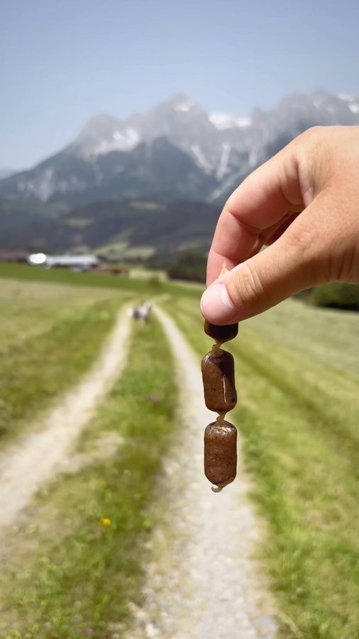 Instagram post by @life.of.bruce.the.aussie for ESSENTIAL FOODS. Caption reads: Sausages and stunning views, what could be....