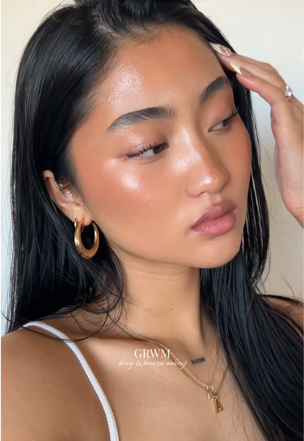 TikTok post by @annejllian for Hourglass Cosmetics. Caption reads: [...] (swim) @Maybelline NY super lock brow gel....