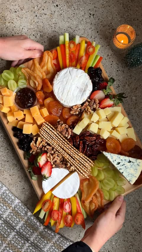 Instagram post by @thatcheeseplate for Caraway Home. Caption reads: Holiday hosting confession: I love making snacks....