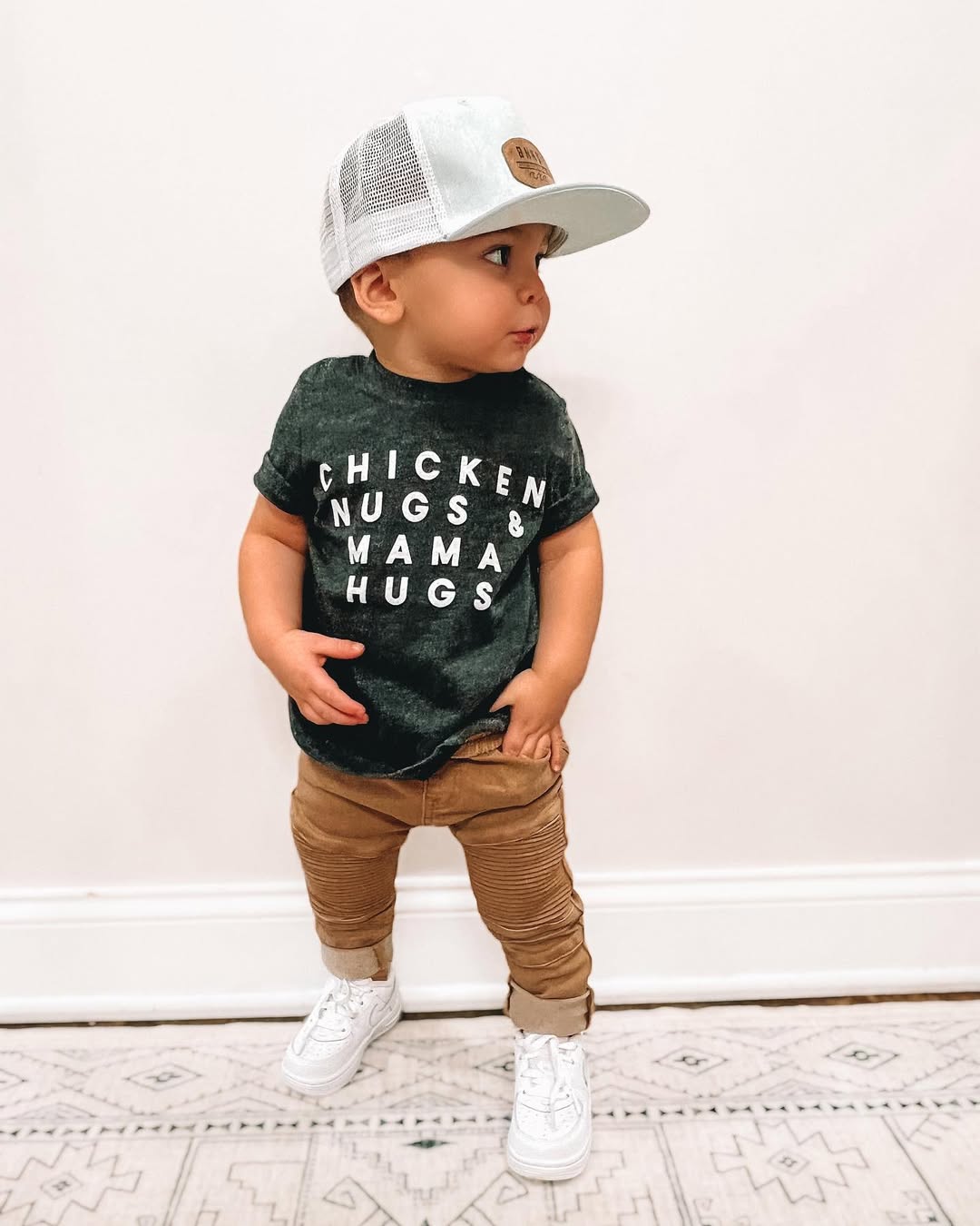 Instagram post by @britneylaurenamarin for Altar'd State. Caption reads: chicken nugs & mama hugs 🖤

hat : @binkybro 
tee....