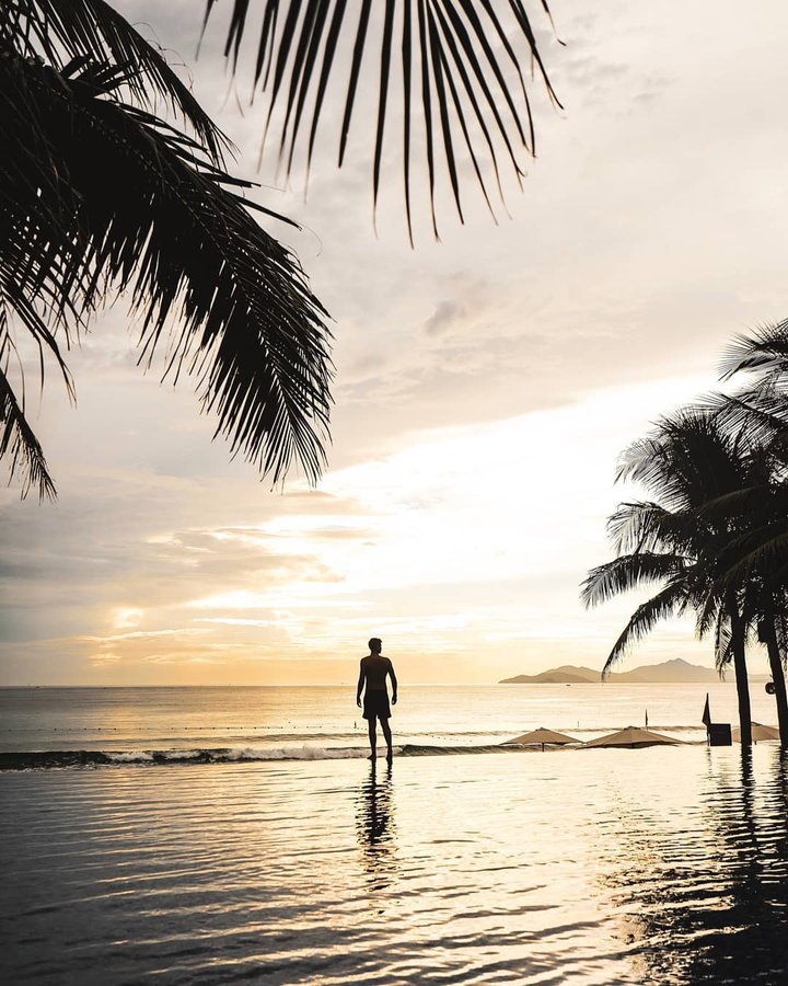 Instagram post by @explorewithlee for Passion Passport. Caption reads: Infinity pools, sun rise, palm trees and the....