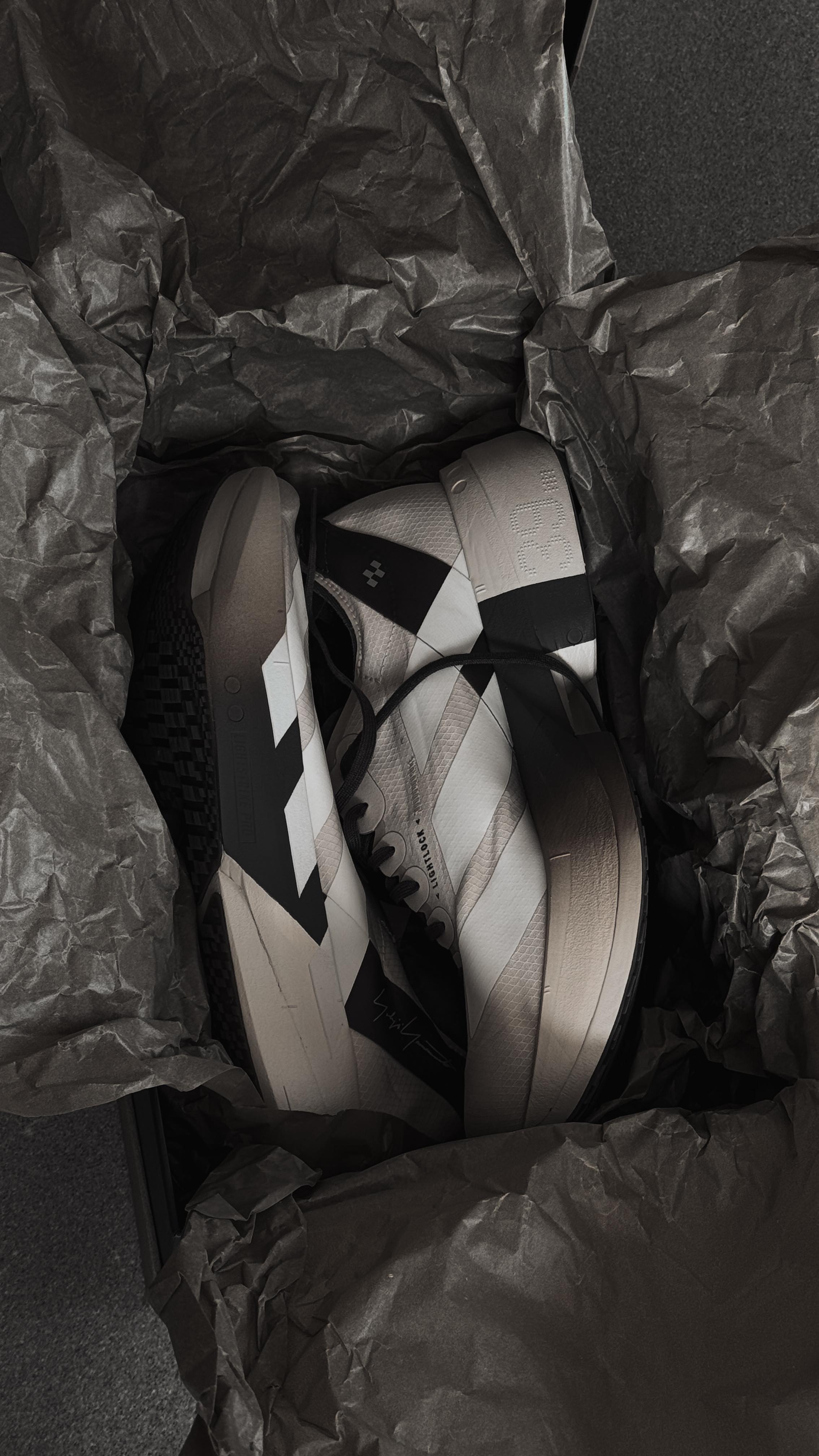 Instagram post by @dezzlim for FARFETCH. Caption reads: Unboxing my ADIDAS ADIOS PRO4 x Y-3....