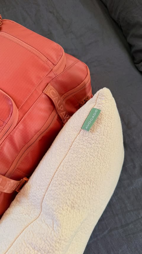 Instagram post by @sophiaxverde for Avocado Green Mattress. Caption reads: Traveling with only a backpack and pillow 🎒☁️....