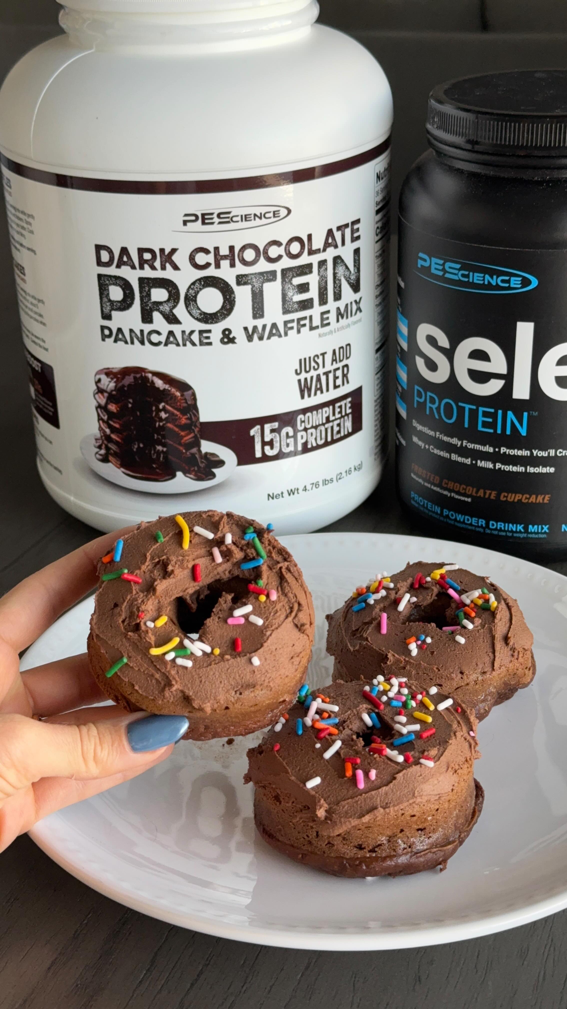Instagram post by @ericananglefit for PEScience. Caption reads: COSMIC BROWNIE PROTEIN DONUTS 🍩🥳  INGREDIENTS:....