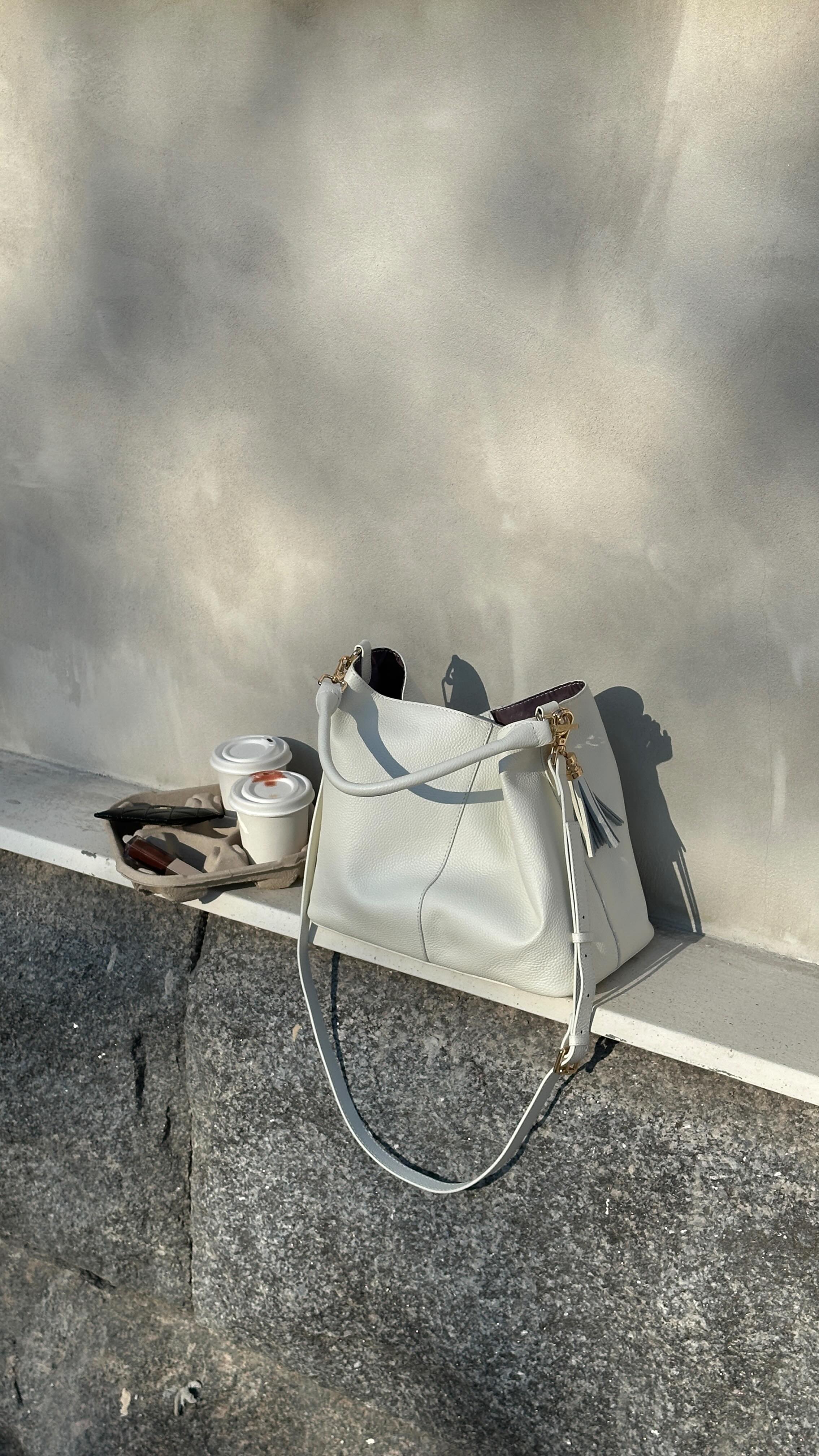 Instagram post by @ninninguyen for Pom Pom London. Caption reads: Quick coffee run ft. @pompomlondon bag 🤍 #ad.