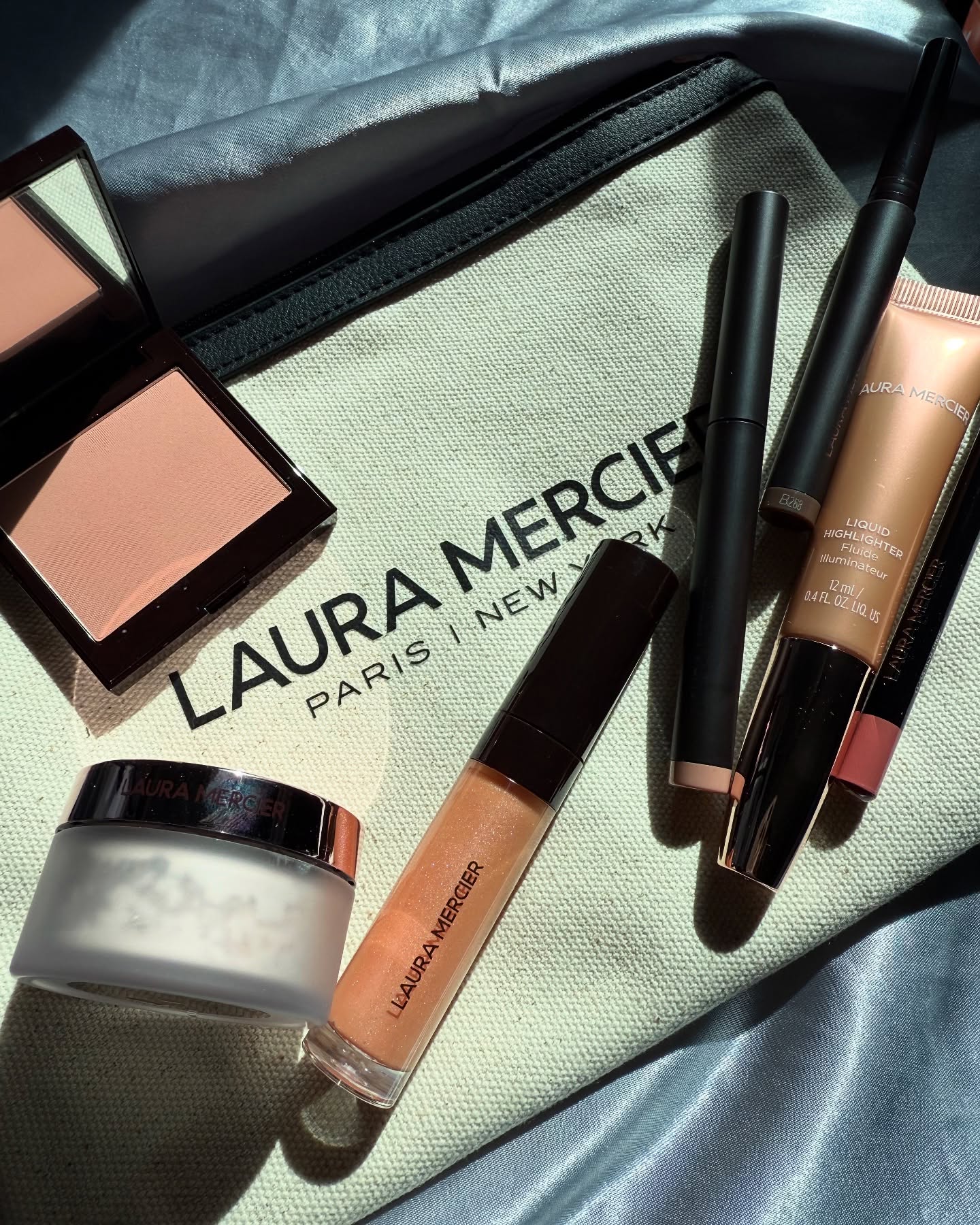 Instagram post by @fun_fearless_beauty for Laura Mercier. Caption reads: My go-to summer essentials from @lauramercier ☀️💄....