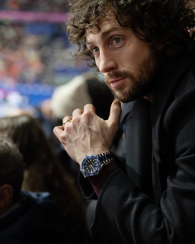 Instagram post by @aarontaylorjohnson for OMEGA. Caption reads: [...] his Planet Ocean to Milano time for an OMEGA....