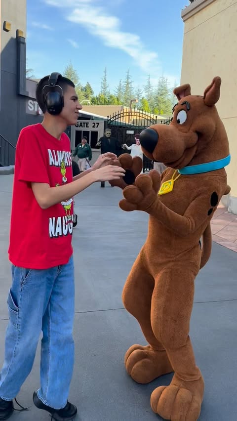 Instagram post by @magicwiththomas for Universal Studios Hollywood. Caption reads: Thomas stimming with joy to see Scooby-Doo walking....