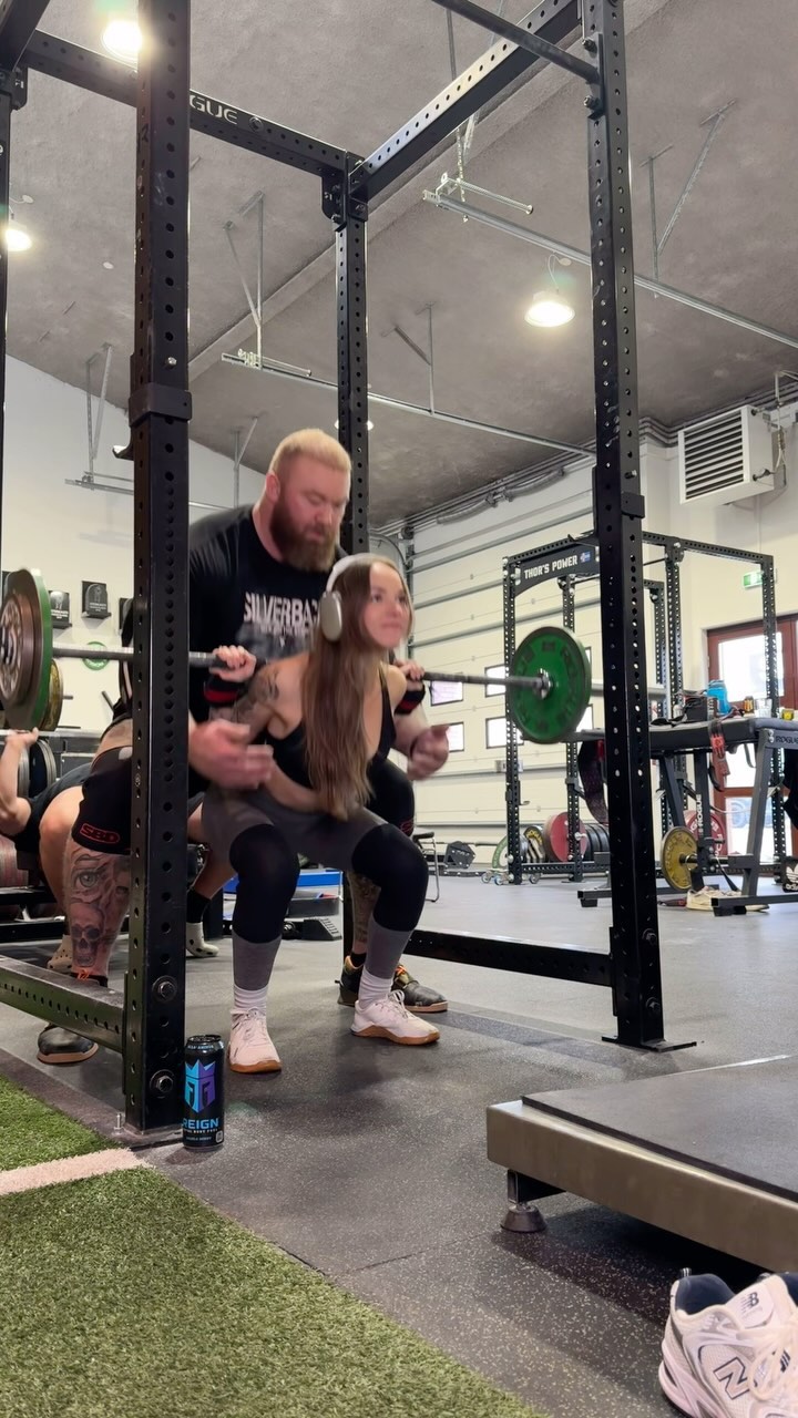 Instagram post by @kelc33 for Reign Body Fuel. Caption reads: World’s strongest spotter. Snuck in there behind....