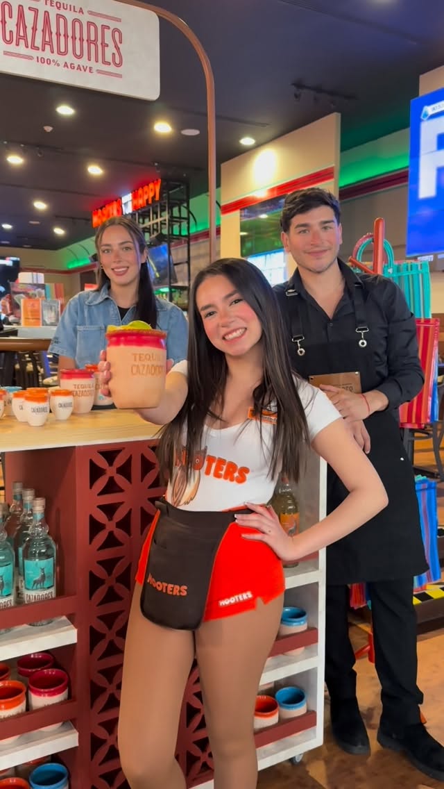 Instagram post by @hootersoasis for Hooters. Caption reads: Tú necesitas un cantarito, yo necesito un....
