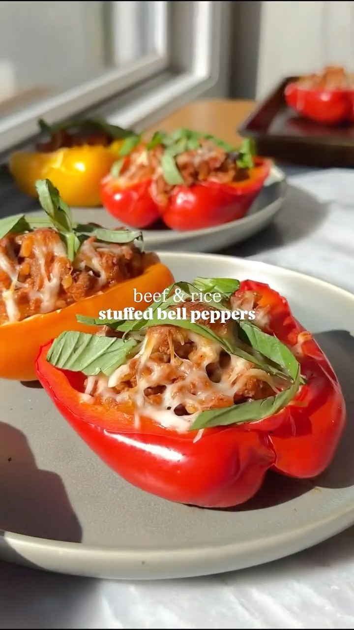 Instagram post by @healthienut for Bertolli. Caption reads: These *beef and rice stuffed bell peppers* are....