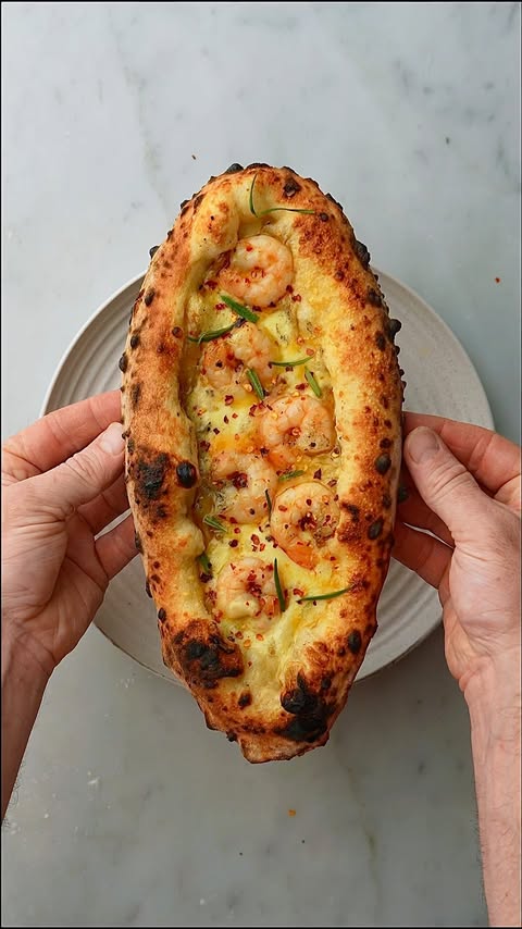 Instagram post by @theoneeighthitalian for Ooni. Caption reads: [...] - Prawns - Chilli flakes 🔥 Baked in the....