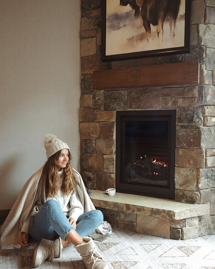 Instagram post by @maria_ponomaryova for Small Luxury Hotels. Caption reads: Ski boots off, fuzzy socks on—this is peak....