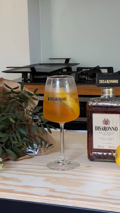 Instagram post by @whymarj for Disaronno. Caption reads: AD Flowers on the table, a Disaronno Spritz in....