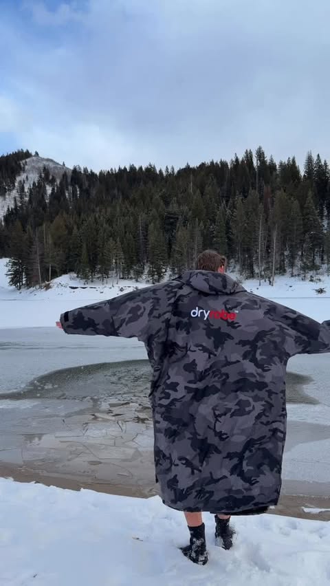 Instagram post by @coldplungecam for dryrobe. Caption reads: [...] frozen reservoir with my pickaxe and my....