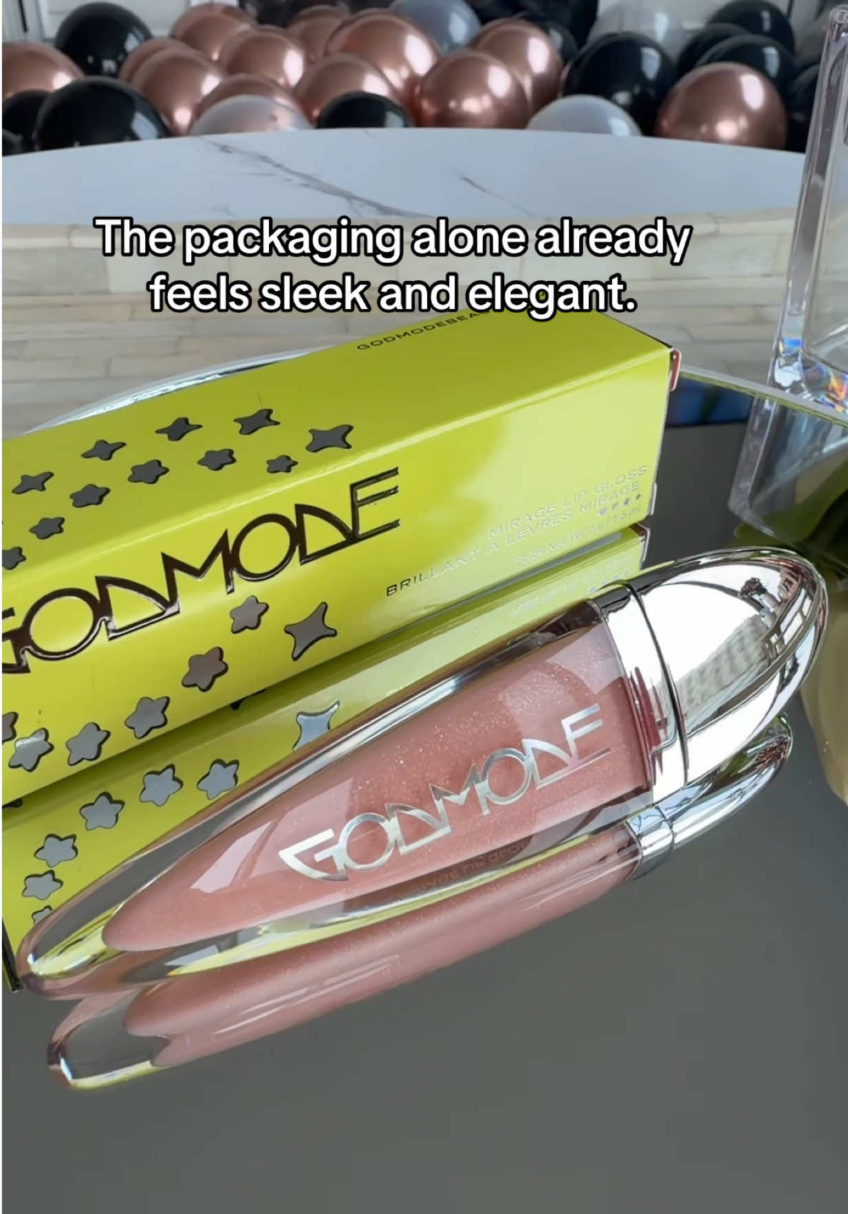 TikTok post by @mia_manhattan_ny for Godmode Beauty. Caption reads: This Godmode Beauty Mirage lip gloss is so pretty.....