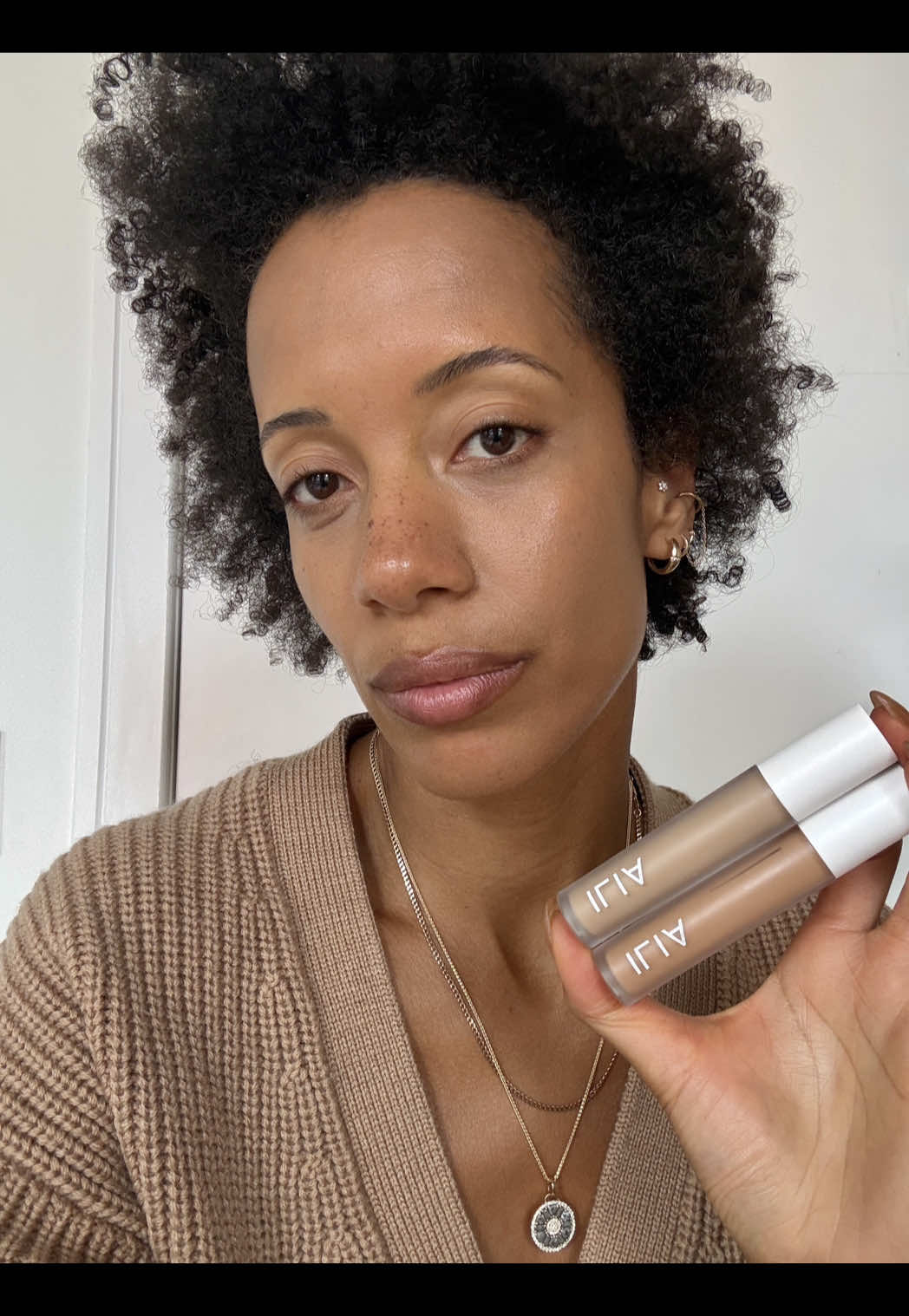 TikTok post by @carlycushnie for ILIA Beauty. Caption reads: [...] this skin blur serum concealer is by @ILIA....