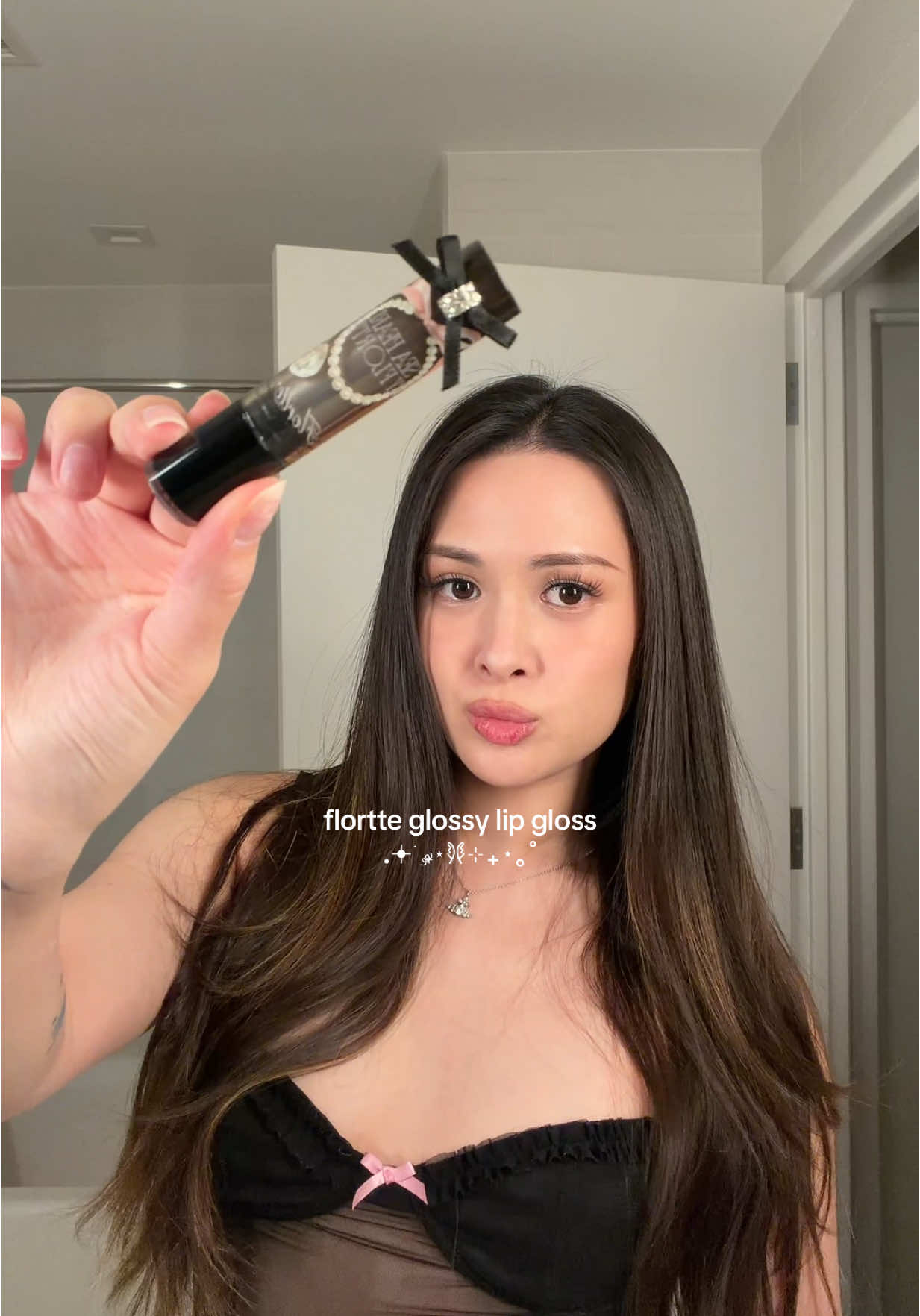 TikTok post by @christineekwan for Flortte Beauty. Caption reads: [...] the lil bow it’s so cutie hehe 🎀🖤....