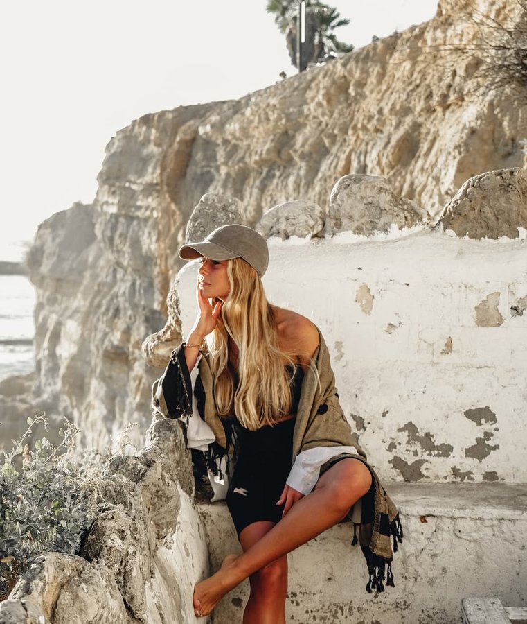 Instagram post by @leonormacedo for Sand Cloud. Caption reads: Last month I was using my towel to lie down in a....