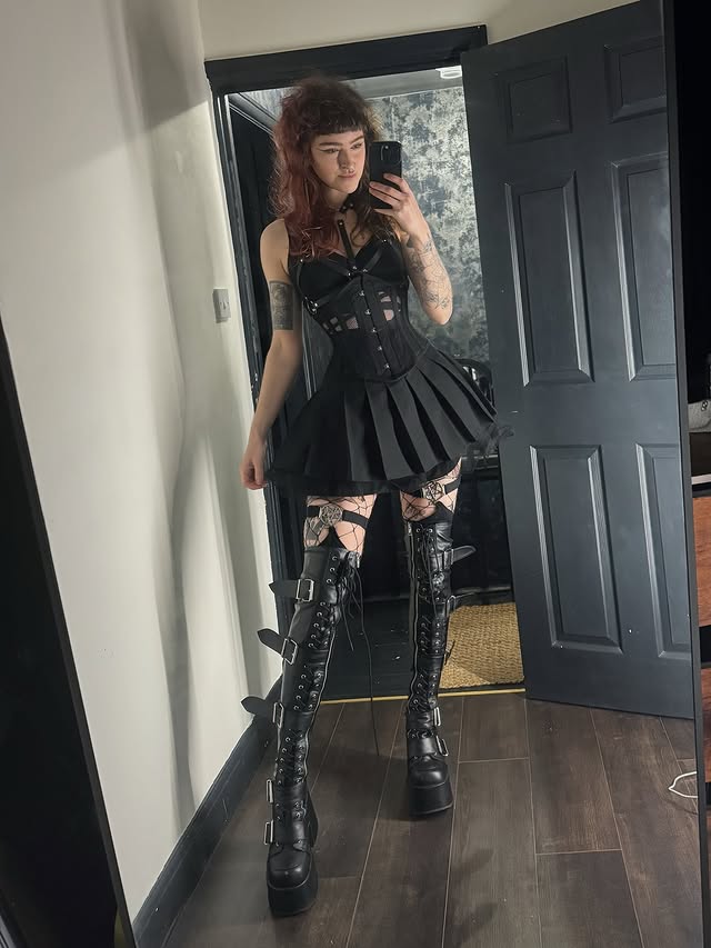 Instagram post by @strawberraemoon for Demonia Shoes. Caption reads: Corsets + thigh high boots 🤝 Corset: @corsetstory....