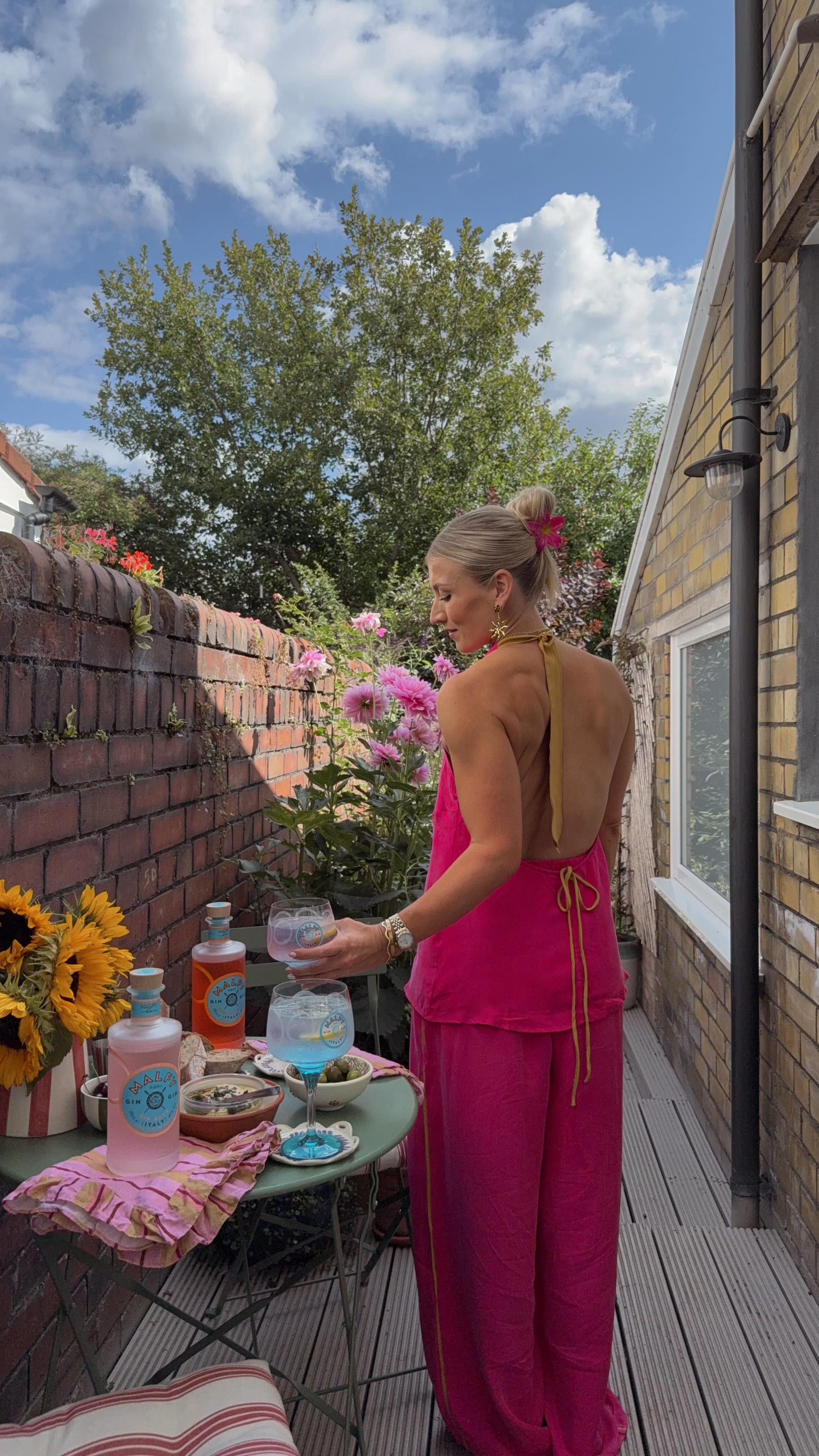 Instagram post by @megbrackpool for MALFY Gin. Caption reads: ad 🌸 if you dress up to sit in the sunny garden....