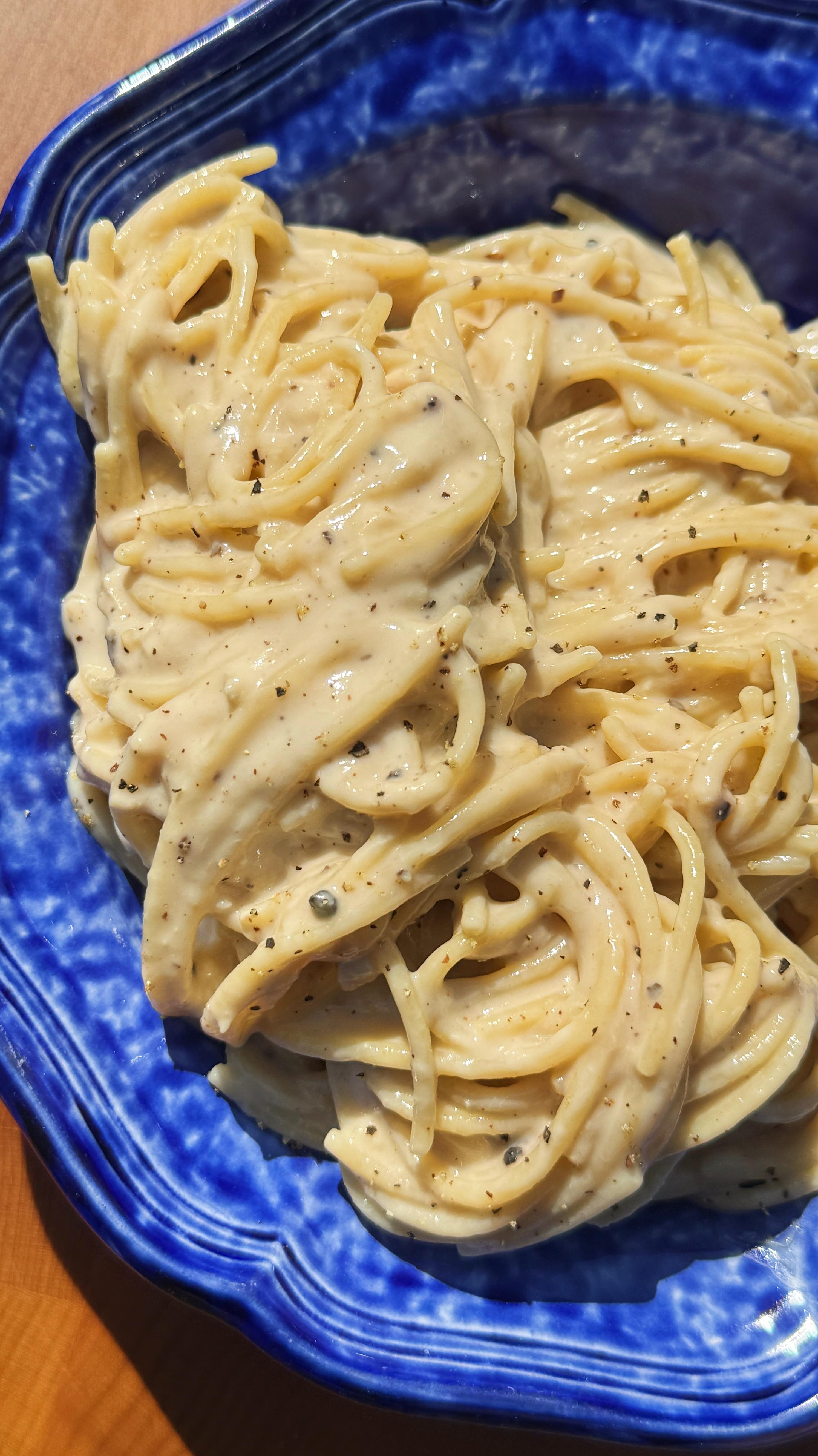 Instagram post by @carolinagelen for NYT Cooking. Caption reads: TUNA CACIO E PEPE — cheesy, comforting and so....