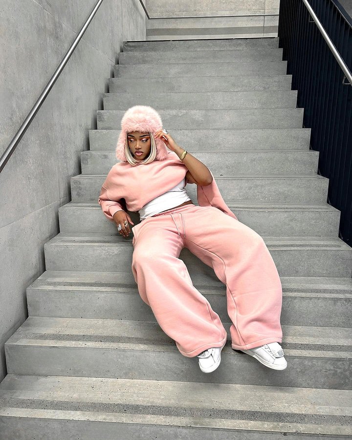 Instagram post by @nidelle.tg for DRMERS CLUB. Caption reads: Bubble gum pink 💕
Tracksuit: @drmersclub....