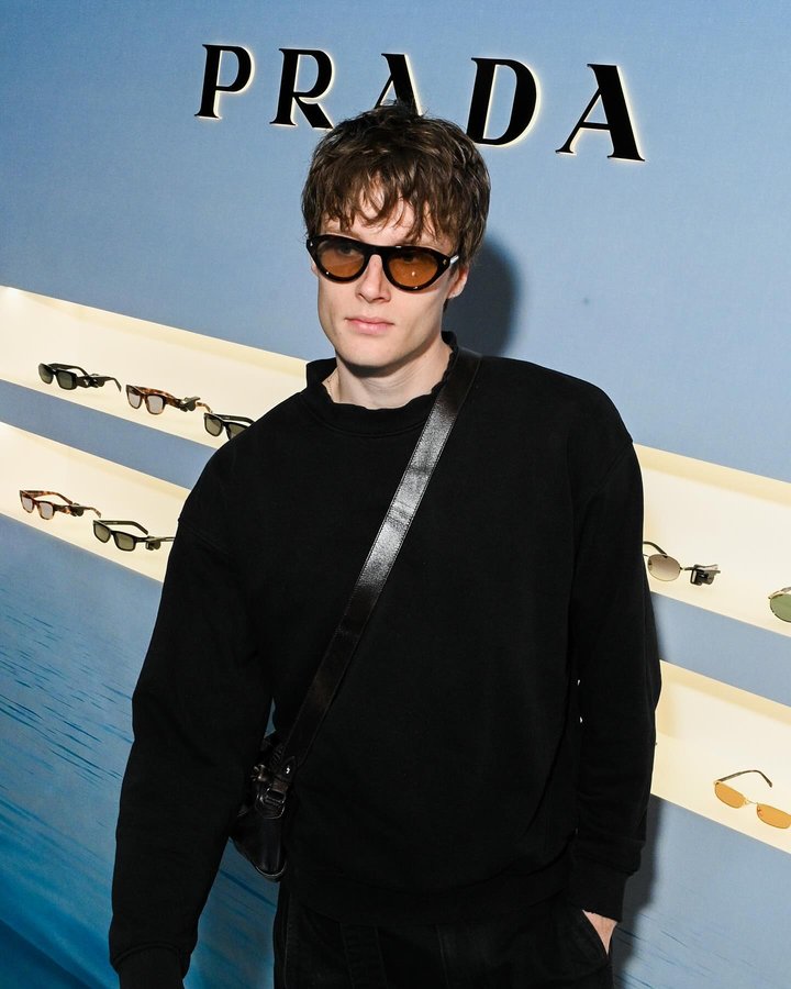 Instagram post by @hughlaughtonscott for EssilorLuxottica. Caption reads: [...] x @libertylondon #PradaEyewear....