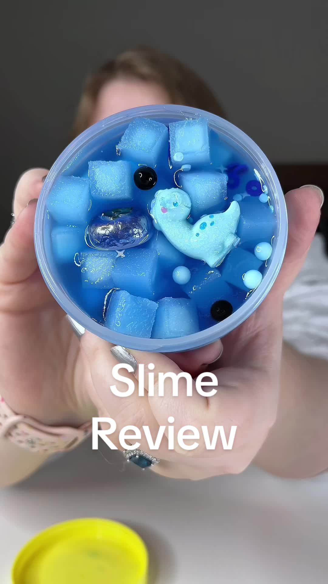 TikTok post by @emilymakesit101 for Peachybbies. Caption reads: [...] Bronto Boba Slime✨🦕🧊🫐@Peachybbies Slime....