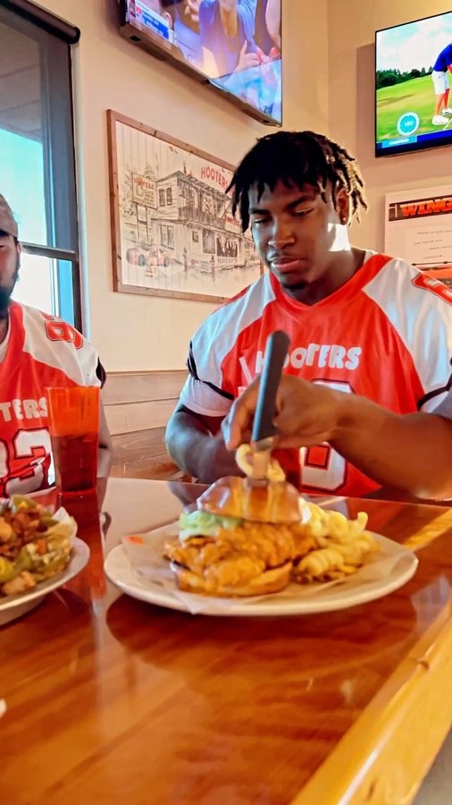 Instagram post by @d1bound.ej for Hooters. Caption reads: [...] college football! Be at your local hooters....