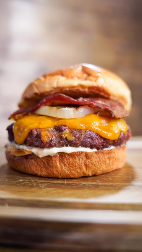 Instagram post by @jenniferdanella for Kamado Joe. Caption reads: These Venison “Crack” Burgers might be the best....