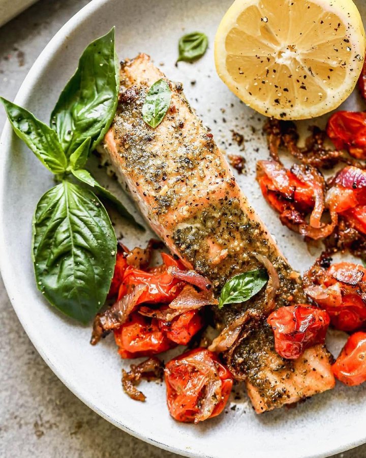 Instagram post by @wellplated for The Kitchn. Caption reads: Sunny Sheet Pan Pesto Salmon is simple, healthy,....