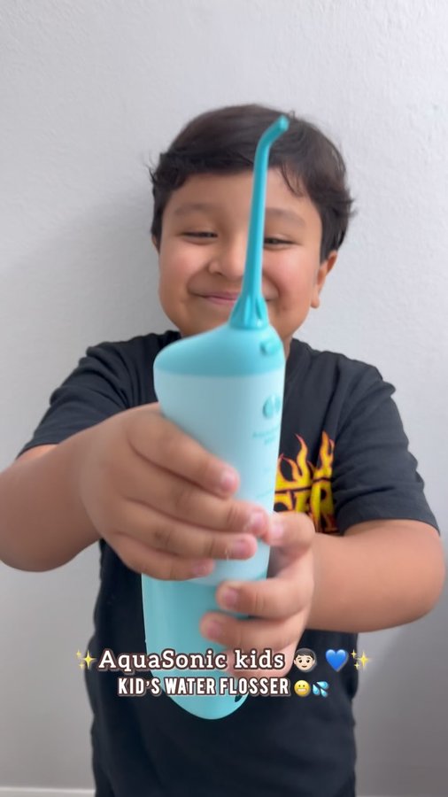 Instagram post by @kimysales_ for AquaSonic. Caption reads: [...] loved this Kid’s Water Flosser from....