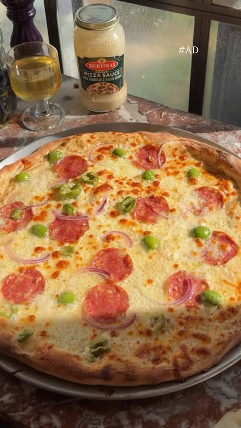 Instagram post by @saturdaytable for Bertolli. Caption reads: #AD Pizza night never fails — the house smells....