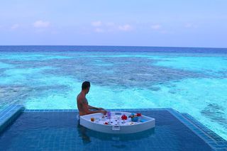 Instagram post by @travelingwithstyle_ for Earth. Caption reads: @centaragrandmaldives 🙏
#blue #ocean #maldives....