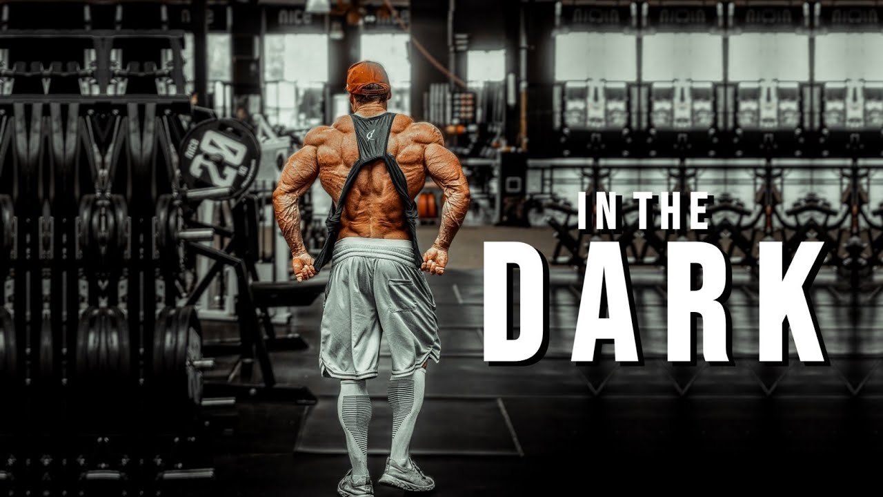 YouTube post by @MuscleBrawn for ENHANCED Labs. Caption reads: CHAMPIONS ARE MADE IN THE DARK 🌑 Gym Motivation.