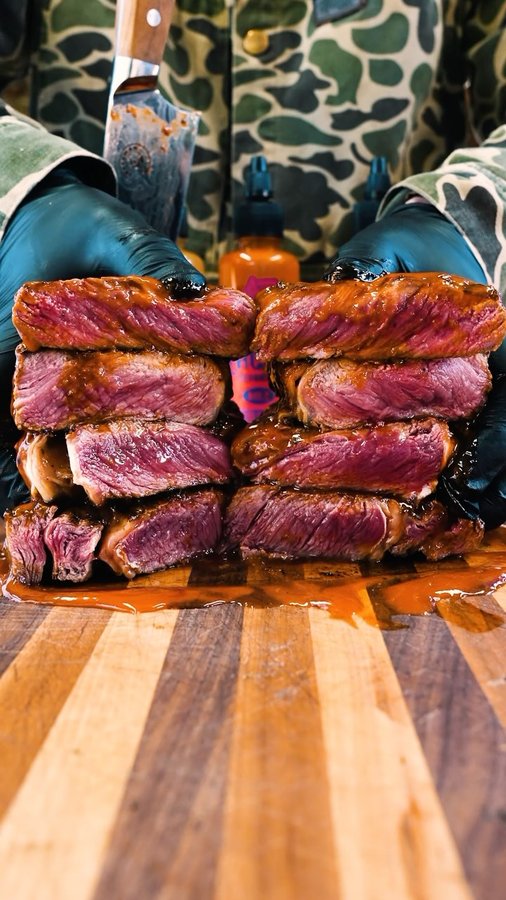 Instagram post by @steakchannel for Flavor God. Caption reads: FLAMBÉ HOT SAUCE STEAKS -Would you try....