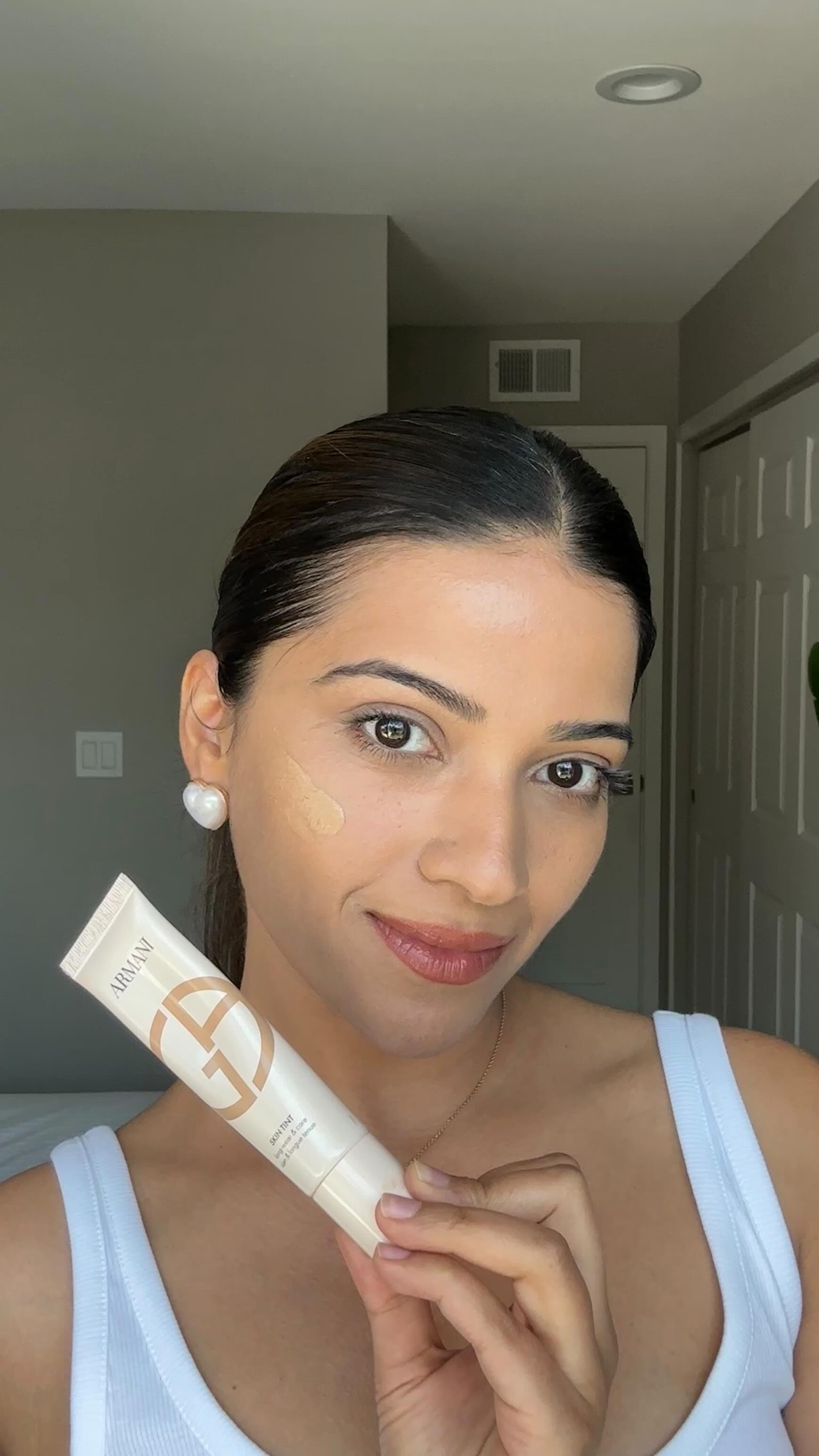 Instagram post by an influencer for Armani beauty. Caption reads: [...] ✨ The new @armanibeauty Skin Tint melts into....