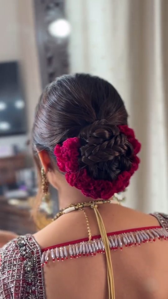 Instagram post by @weddingplzbrides for WeddingPlz.com. Caption reads: Elegant bun adorned with vibrant red blooms ✨
A....